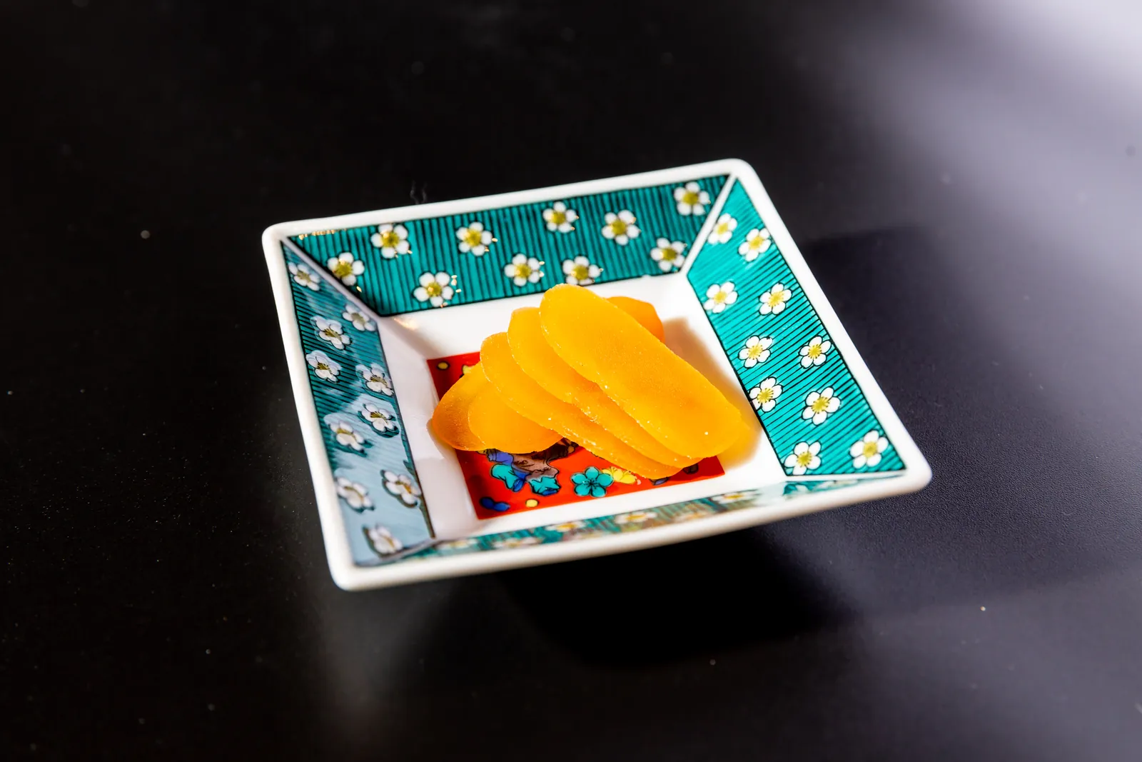 色絵の小皿に盛り付けた橙色の一品